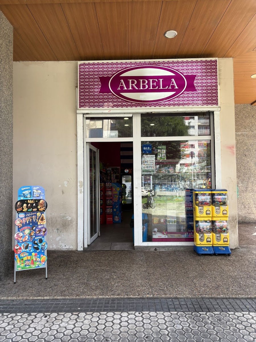 Fachada de la tienda Arbela, con su cartel rosa y las máquinas de bolas en la puerta